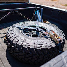 Load image into Gallery viewer, sdhq built spare tire brackets installed in bed of truck with spare tire display
