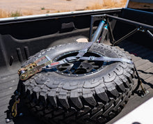 Load image into Gallery viewer, display of sdhq built universal spare tire brackets installed in bed of truck with spare tire